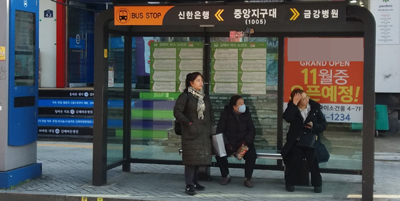 김해시가 한파에 대비해 버스정류소 난방시설물을 확대 설치하는 가운데 사진은 마련된 발열의자에 앉아 버스를 기다리는 시민들의 모습.