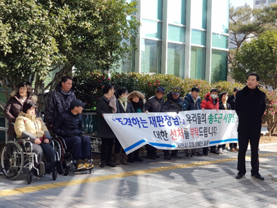 사천시 지체장애인 100여 명이 법원 앞에서 현수막을 들고 송 시장의 선처를 호소했다.