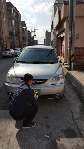 김해시가 자동차세ㆍ과태료 체납차량을 대상으로 번호판을 영치하고 차량 전면 유리에 영치증을 부착하고 있다.