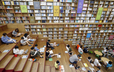 시민들이 도서관에서 자유롭게 앉아 책을 읽고 있다.