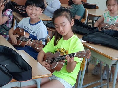 경화초등학교 학생들이 음악 강사와 협력 수업에서 우쿨렐레 악기를 연주하고 있다.