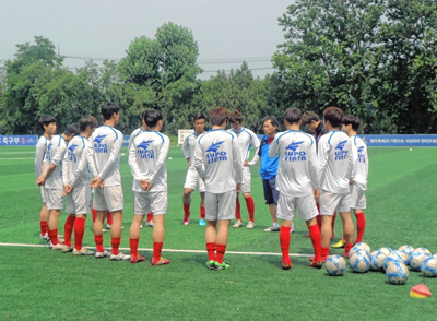 축구지도자로 활동 중인 이현우 대표가 경기 전 선수들과 작전을 나누고 있다.