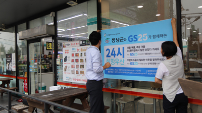 GS25 가맹점 유리에 ‘24시 희망우산’ 홍보 현수막을 설치하고 있다.