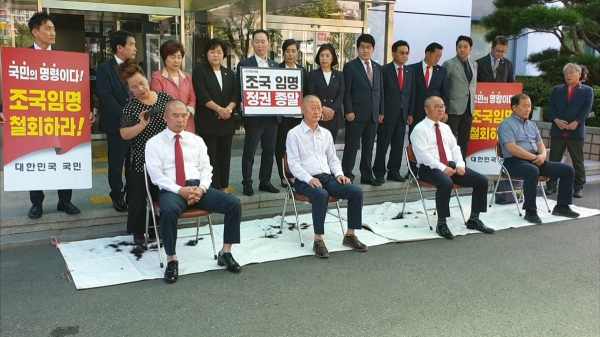 자유한국당 창원시의원 4명이 18일 창원시의회 정문 앞에서 조국 장관의 사퇴를 촉구하며 머리를 깎고 있다.