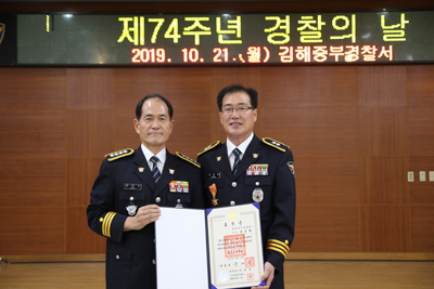 김해중부경찰서 연지지구대장 정종화 경감(오른쪽)이 21일 옥조근정훈장을 받고 김한수 서장과 기념사진을 찍고 있다.