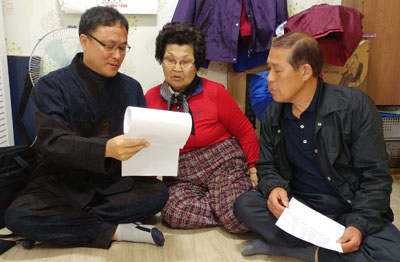 정재상 소장(좌측)과 김승탁 선생의 딸 김부자, 조카 김영수 씨가 ‘포상 안내문’을 보고 있다.