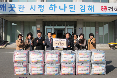 지난 13일 국제위러브유운동본부가 김해시를 방문해 이불 25채를 기탁한 뒤 기념사진을 찍고 있다.