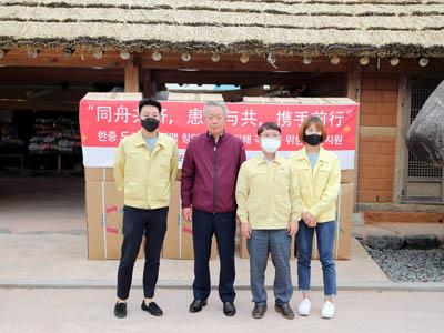 윤상기 하동군수(왼쪽 두 번째)와 군 관계자들이 중국 칭다오시 칭양구가 기탁한 이불세트를 두고 기념촬영을 하고 있다.