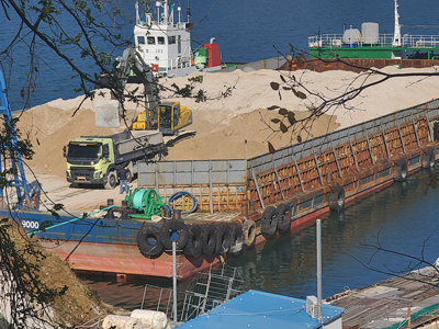 지난달 30일 통영시 북신만에 굴 폐패각 5500톤을 실은 바지선이 도착해 하역 작업하고 있다.