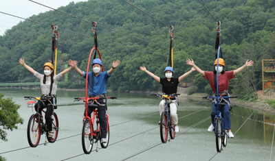 함안 입곡군립공원을 찾은 체험객들이 ‘아라힐링사이클’을 타고서 하늘을 달리는 즐거움을 만끽하고 있다.