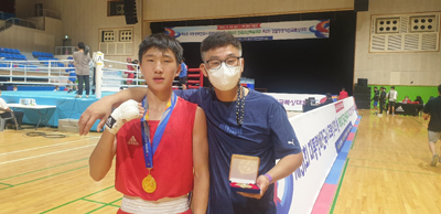 김해대곡중학교 복싱부 이동현(왼쪽) 선수와 김효현 코치가 금메달을 딴 후 기념사진을 찍고 있다.