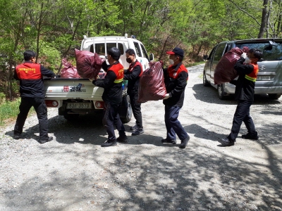 지난 22일 김해시 산불진화대원이 임도 변에 버려진 쓰레기를 수거하고 있다.