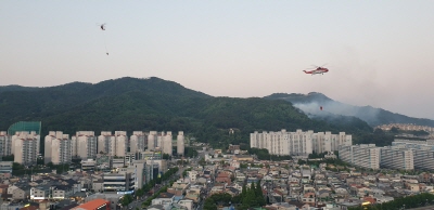 지난 22일 오후 경남 김해시 구산동의 한 야산에서 산불이 발생해 산불진화헬기가 불을 끄고 있다.  연합뉴스