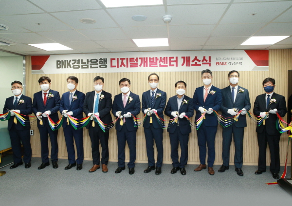 ﻿BNK경남은행 최홍영(왼쪽 다섯 번째) 은행장과 IT사업 진행 중인 개발 협력사 대표들이 디지털개발센터 개소 축하 테이프를 자르고 있다.