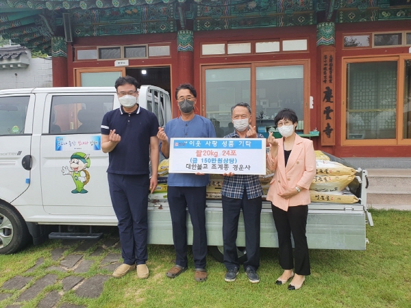 ﻿김해 경운사 관계자 등이 내외동행정복지센터에 이웃돕기 쌀을 기탁한 뒤 기념사진을 찍고 있다.