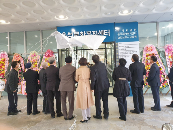 ﻿김해 은석문화복지센터 개원식에 앞서 참석자들이 현판 가림막 걷기를 하고 있다.