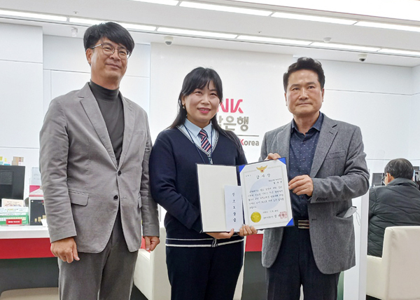 ﻿BNK경남은행 대청지점 청원경찰(가운데)이 김해서부경찰서 수사과장 전기환 경정으로부터 감사장을 받고 있다.