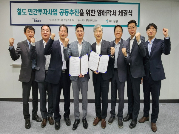 ﻿김정훈(왼쪽에서 네 번째) 현대로템 레일솔루션본부장과 전호진 하나은행 IB사업본부장이 MOU를 체결 후 기념촬영을 하고 있다.