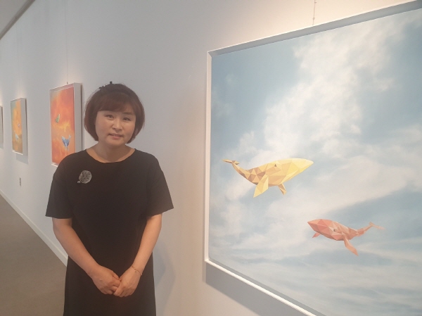 ﻿김결희 작가가 지난 15～18일 양산문화예술회관에서 열린 `푸른달 구름전`에서 작품 앞에서 포즈를 취하고 있다.