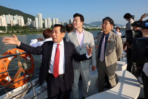 ﻿나동연 양산시장이 낙동강 생태탐방선에서 윤영석 국회의원과 홍태용 김해시장에게 낙동강 사업에 대해 설명하고 있다.