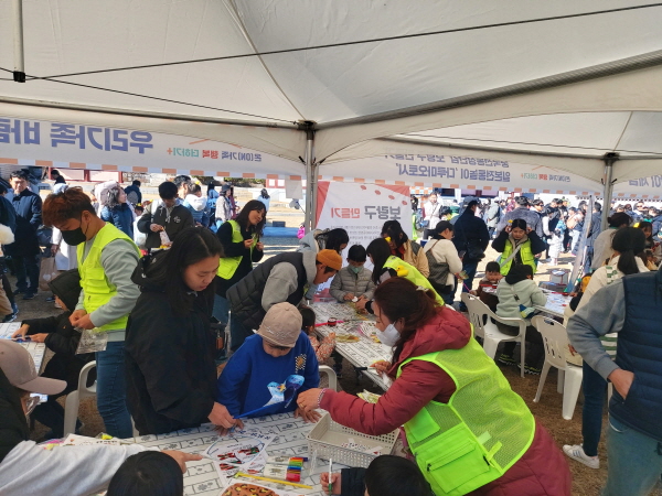 ﻿김해시가족센터가 주최한 2023년 '온(ON) 가족 행복더하기' 부스체험에 참여한 가족들이 바람개비를 만들고 있다.