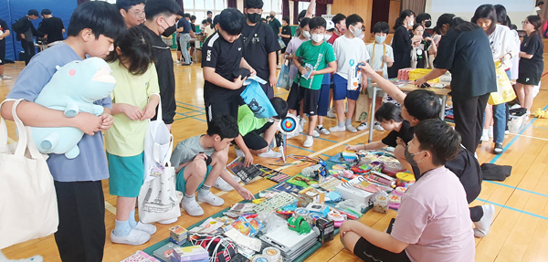 ﻿칠서징검다리 동아리가 환경주간에 운영한 별별 마켓에서 학생들이 중고 물품을 고르고 있다.