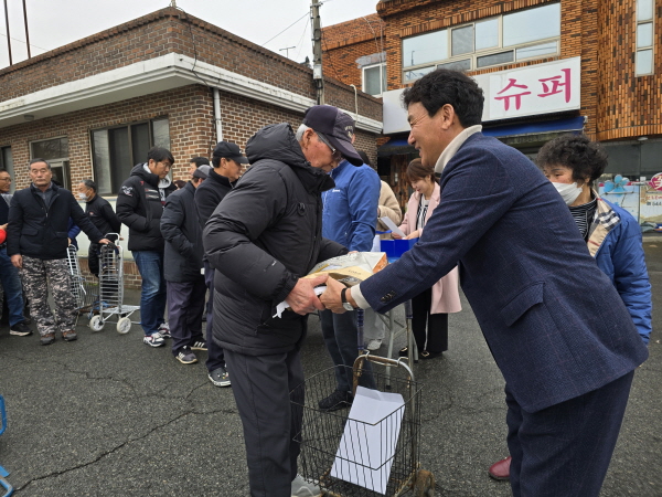 ﻿김일용 진해수협 조합장이 조합원들에게 결산배당 및 설명절 위문품을 전달하고 있다.
