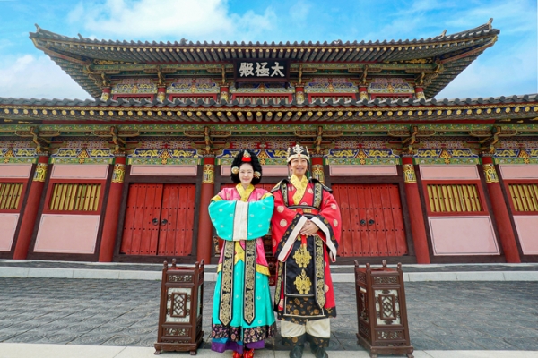 ﻿허왕후 오페라에서 착용했던 의상을 입은 남녀가 김해가야테마파크 태극전 앞에서 포즈를 취하고 있다.